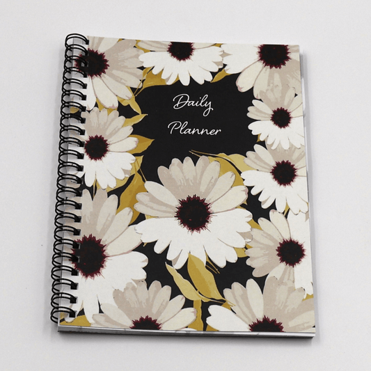 A5 Daily planner with white daisy floral design on a black background. Laminated flexi-cover.
