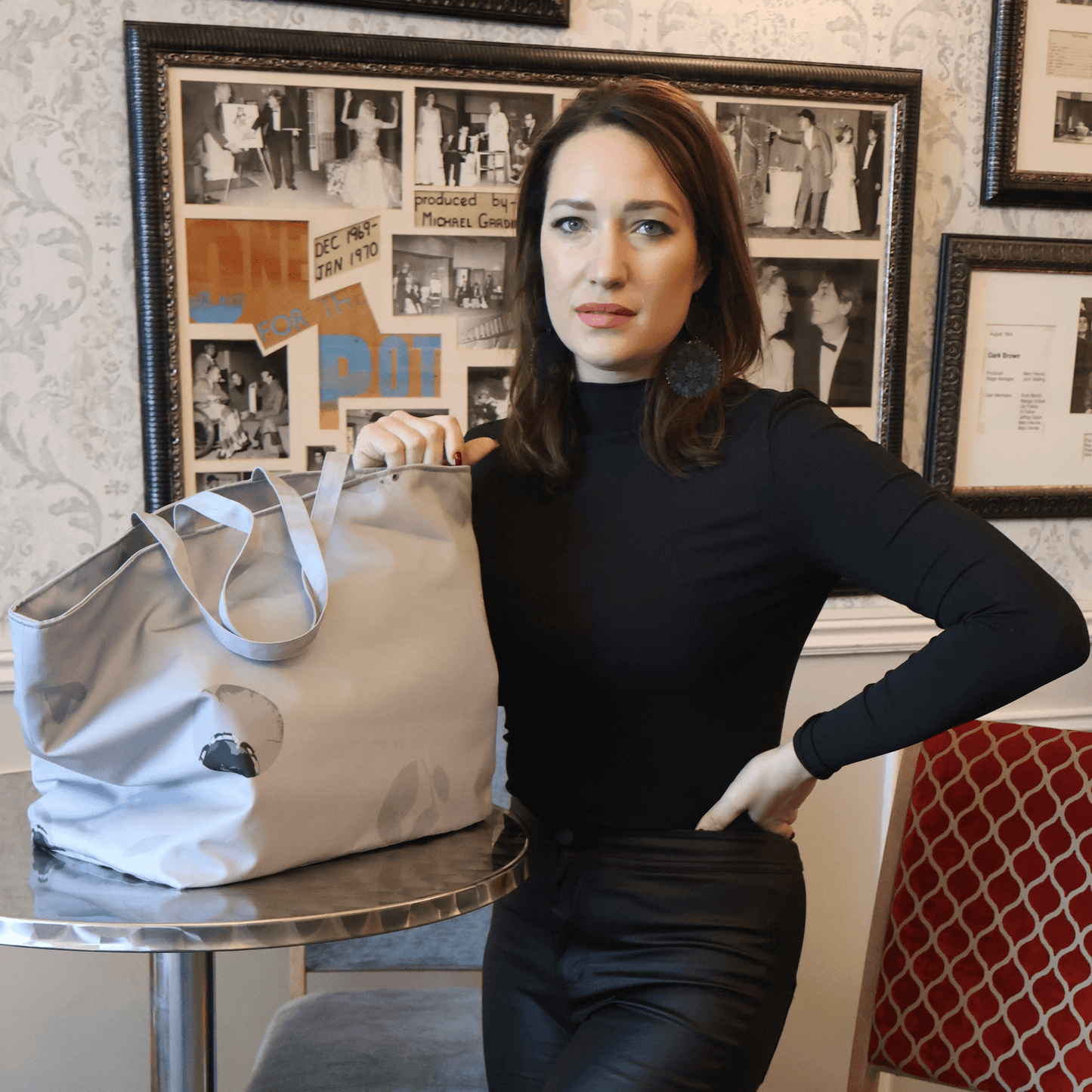 Model with a silver grey carryall bag with abstract floral design.