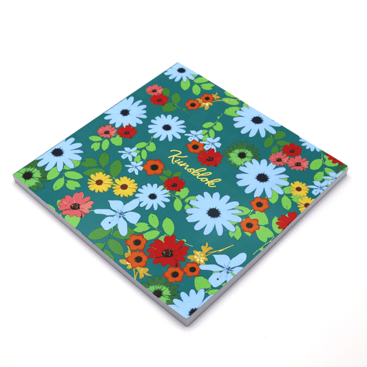 Square art pad in bright daisy floral design on a blue background. Side binding.