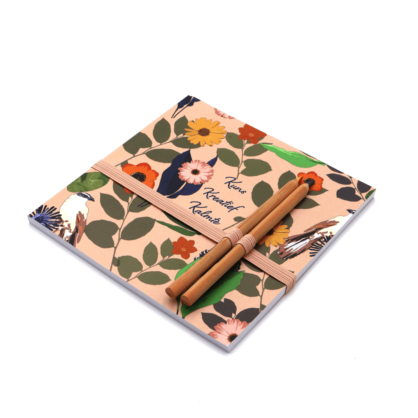 Square art pad with pencils and pencil holder with bright daisy floral design on a soft peach background.