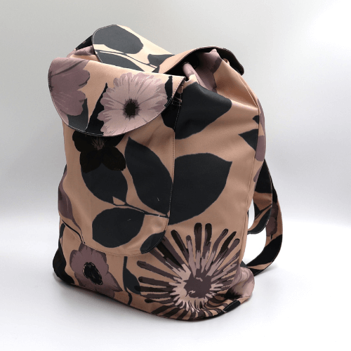 Lightweight backpack with drawstring and daisy floral design in mauve and dusky peach. Side view.