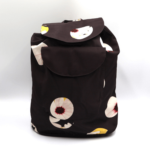 A lightweight, durable backpack with White Daisy design on a black background. High-quality materials.