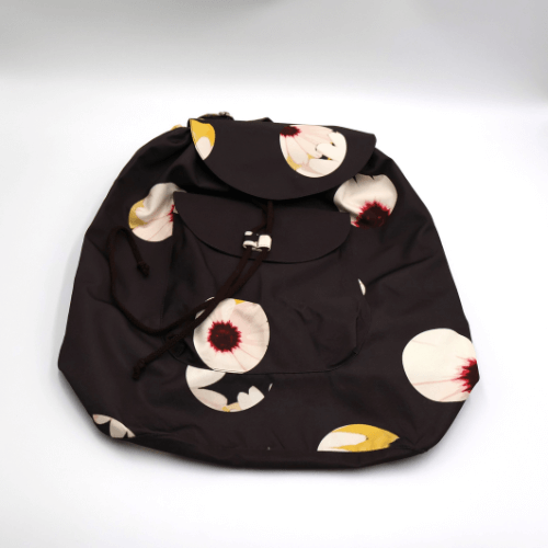 A lightweight, durable backpack with White Daisy design on a black background. High-quality materials. Flat view.