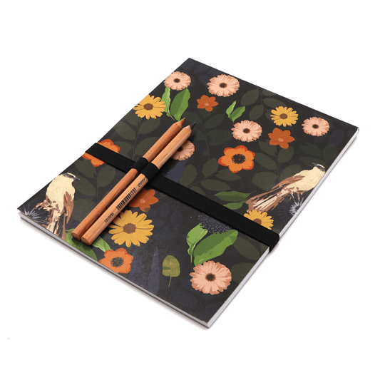 Sketchpad with pencils and pencil holder. Bright daisy floral design on black background.