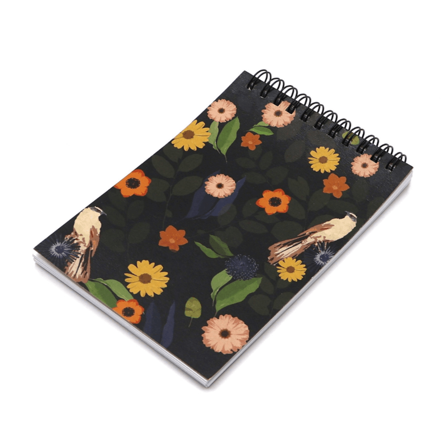 A6 Notebook with bright daisy design on a black background. Top wire binding.
