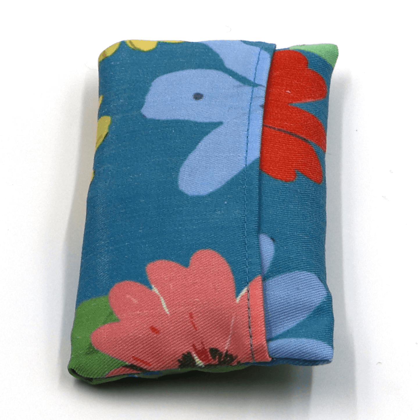 Fold up shopping bag with bright daisy design on a blue background. Fold view.