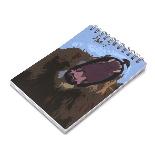 A6 Notebook with face of yawning lion on a blue background. Top wire binding.