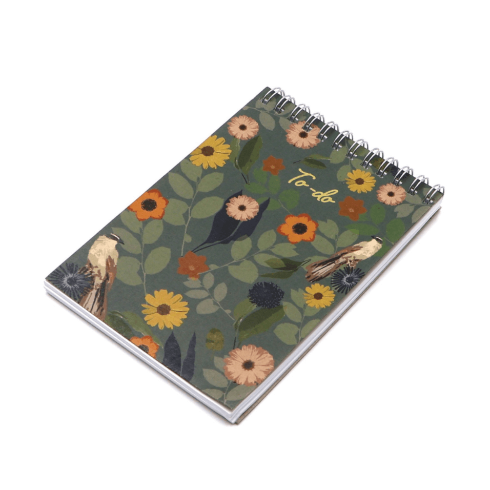 A6 Notebook with bright daisy floral design on dark green background. Top binding.