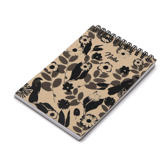 A6 Notebook with daisy floral design in black on a beige sand background. Top binding.