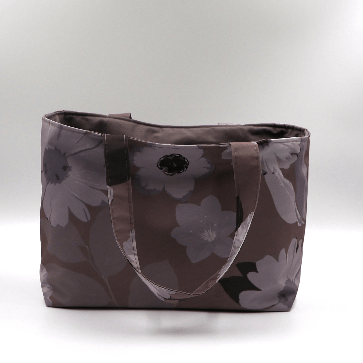 Teacher/book bag with light grey and mauve floral design on a dark mauve background. Carry books and crafts. Front view.