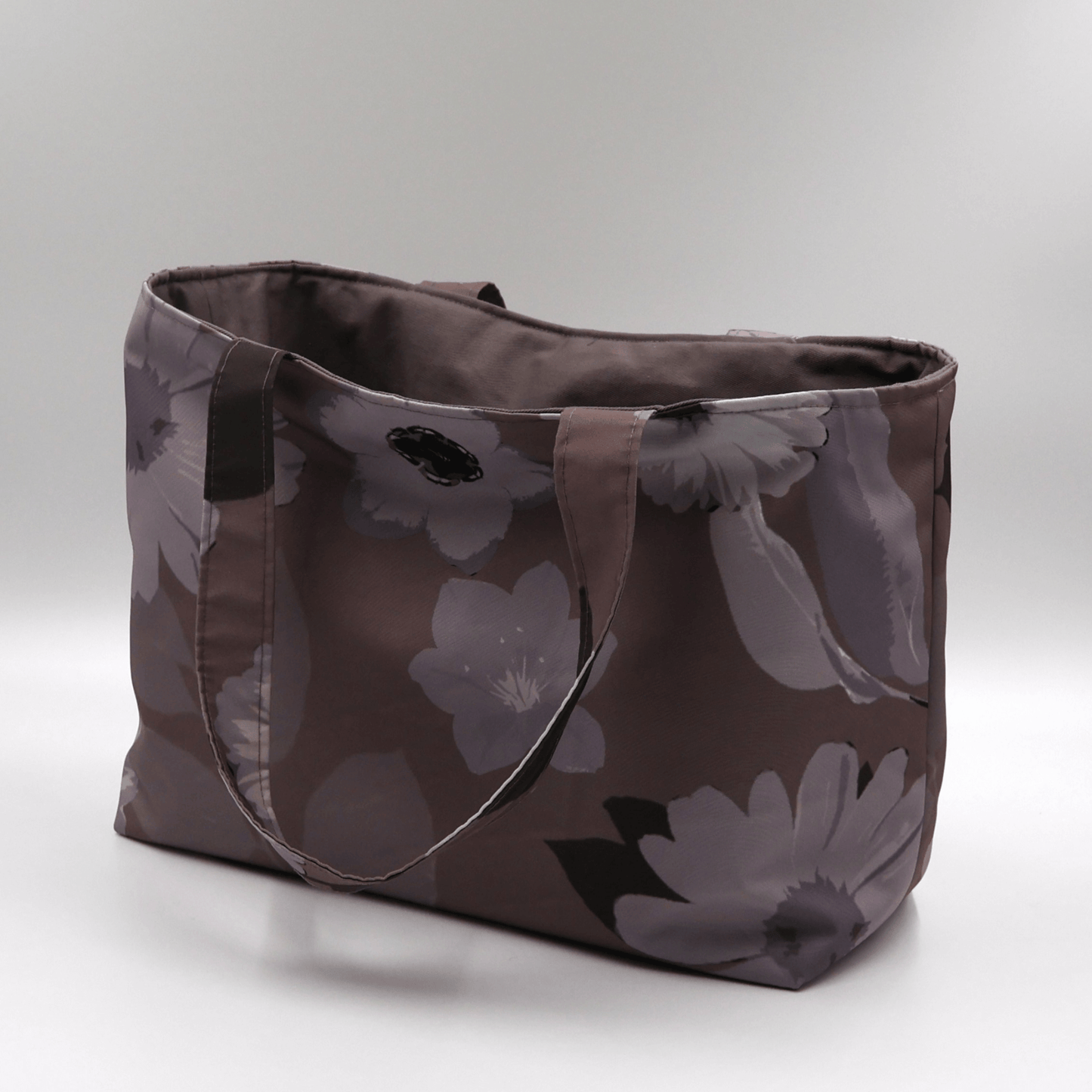 Teacher/book bag with light grey and mauve floral design on a dark mauve background. Carry books and crafts. Side angle.