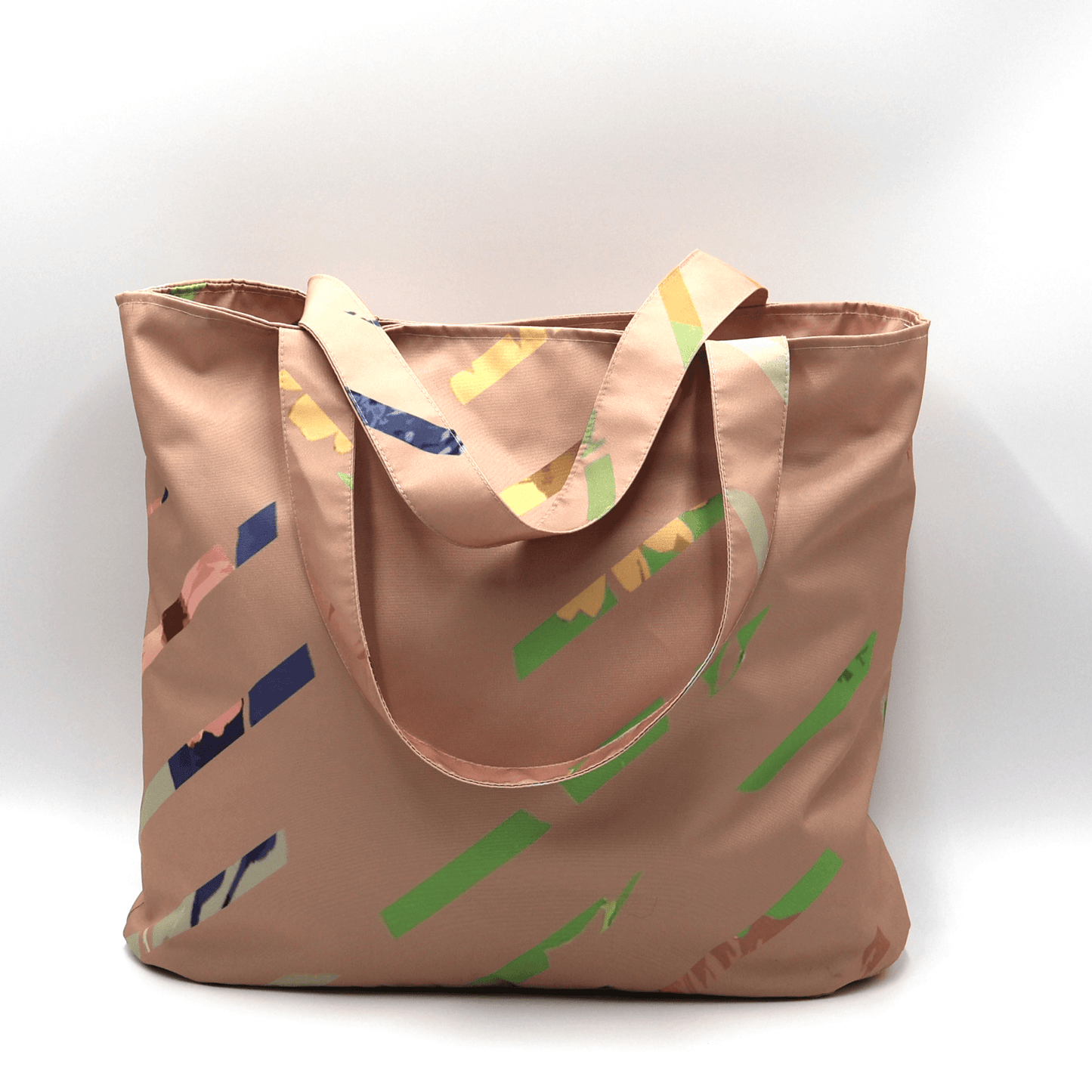Shoulder bag with bright stripe design on a dusky peach background. Perfect for carrying books and documents.