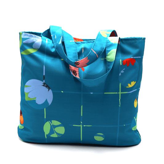 Shoulder bag with bright daisy floral design on blue background. Durable, easy to clean fabric.