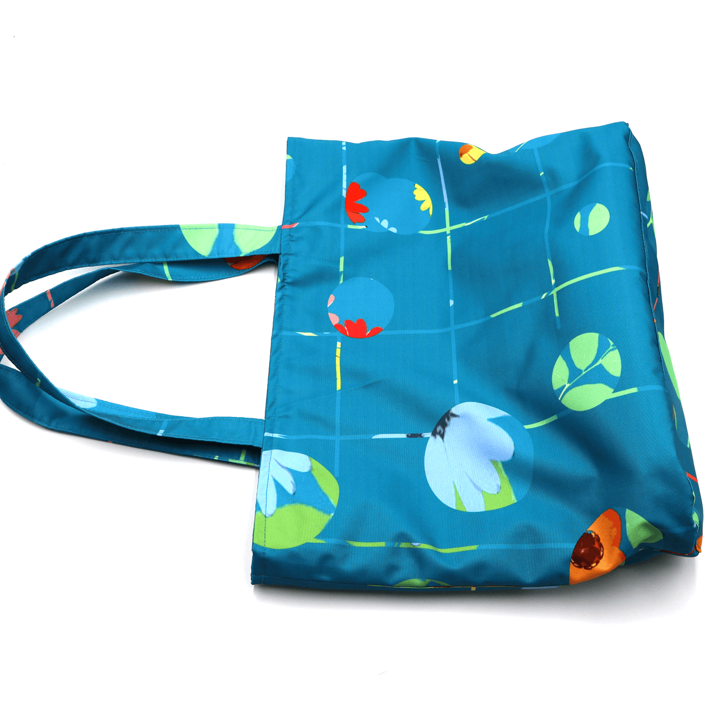 Shoulder bag with bright daisy floral design on blue background. Durable, easy to clean fabric. Flat view.