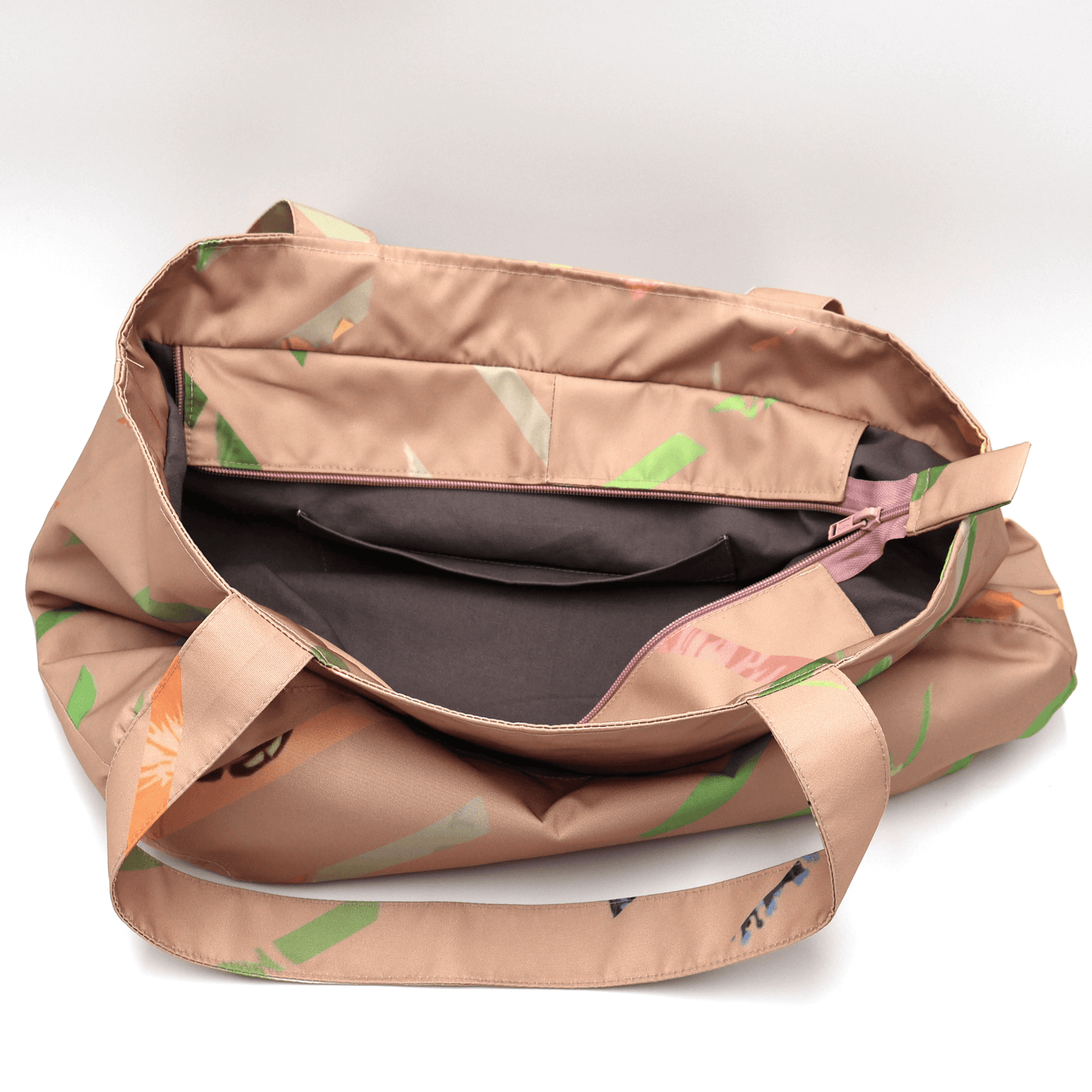Shoulder bag with bright stripe design on a dusky peach background. Perfect for carrying books and documents. Open view.