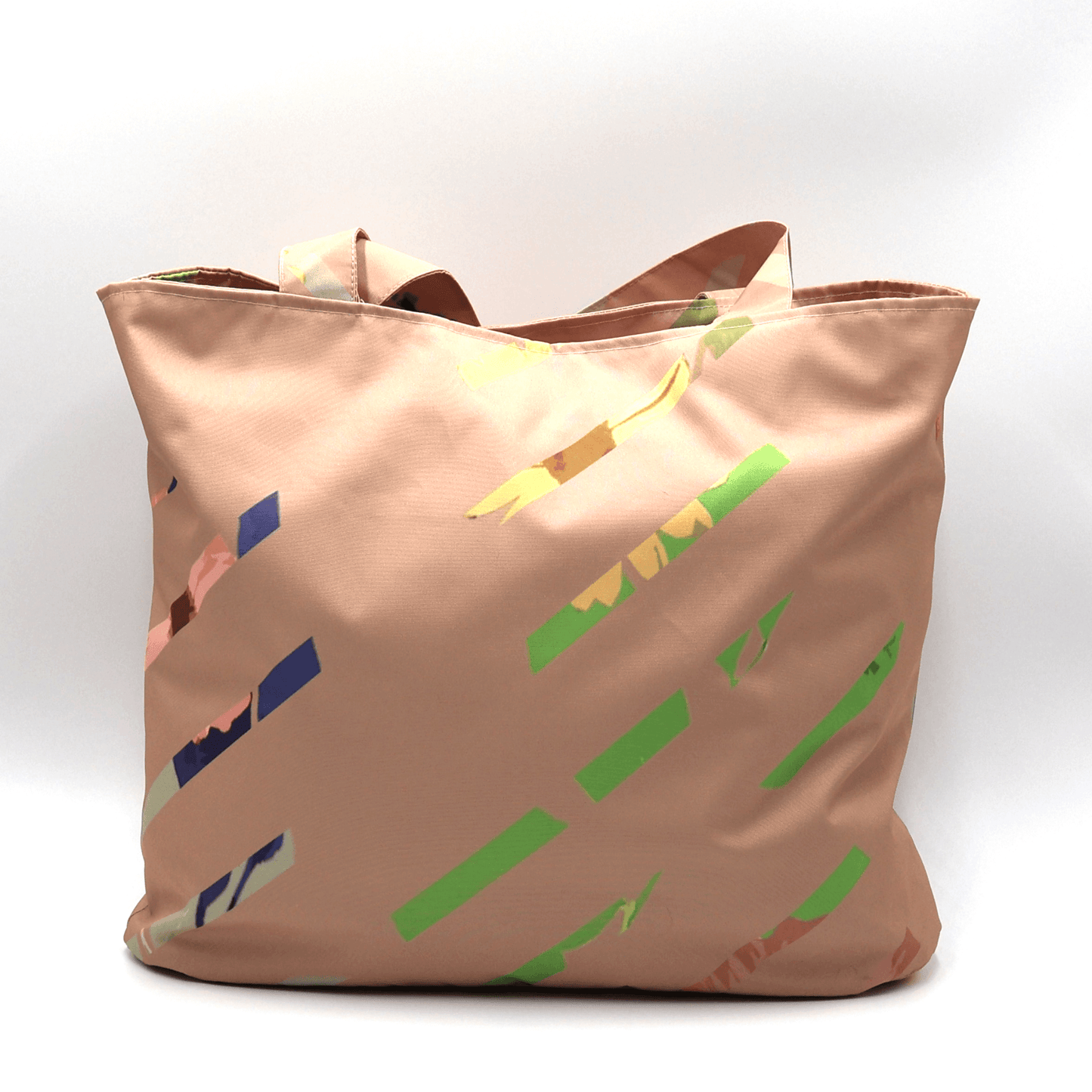 Shoulder bag with bright stripe design on a dusky peach background. Perfect for carrying books and documents. Front view.
