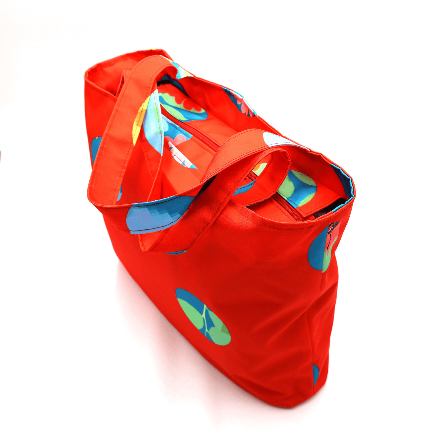 Shoulder bag with bright daisy floral design on a red background. Perfect for carrying books and documents. Top and side view.
