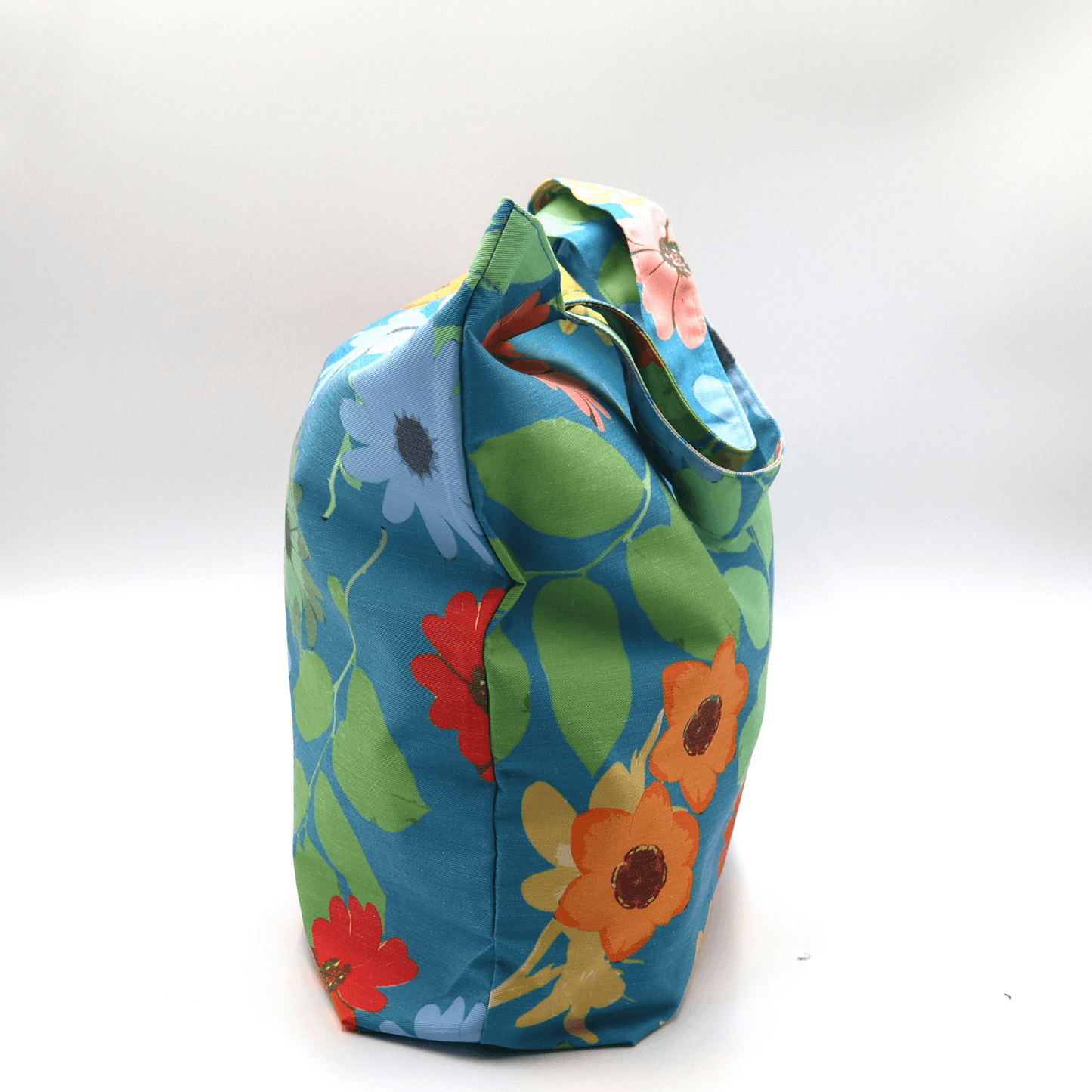 A bright, beautiful tote bag with Daisy design on a blue background. Perfect finishes. Side view.