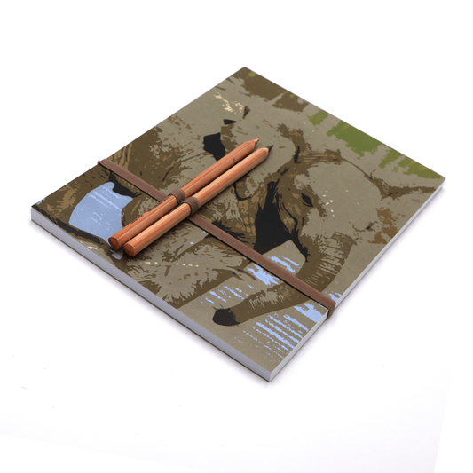 A4 sketchpad with pencils and pencil holder with baby elephant design on light blue background.