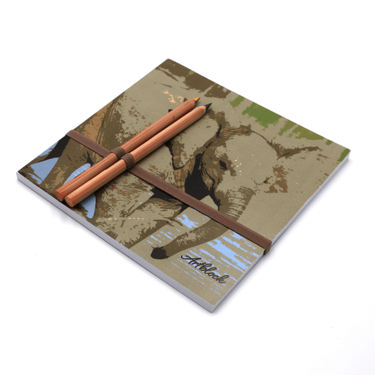 Square art pad with pencils and pencil holder with baby elephant design on light blue background.