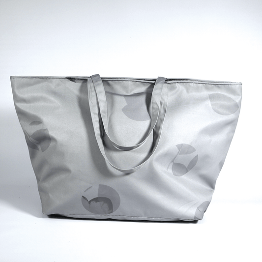 A silver grey carryall bag with abstract floral design.