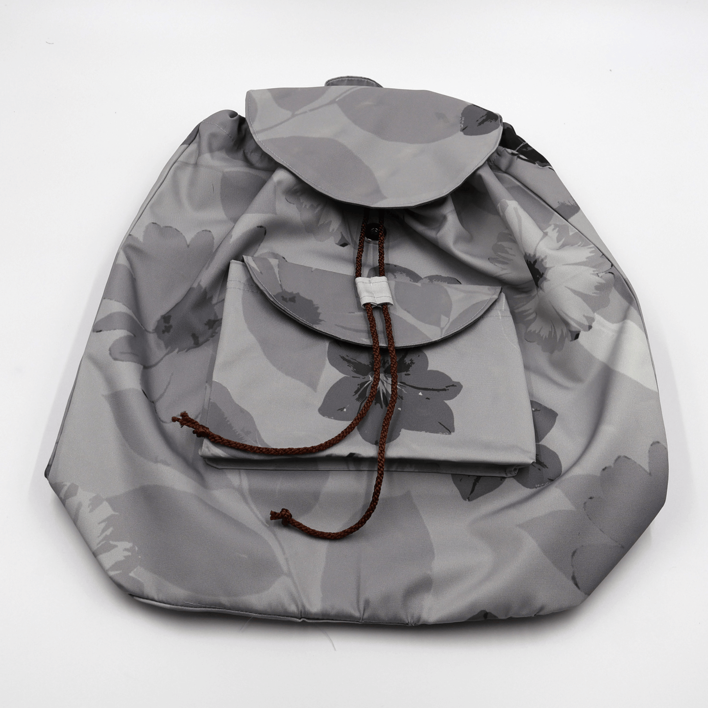 Lightweight backpack with drawstring and daisy floral design in dark and light greys. Flat View.
