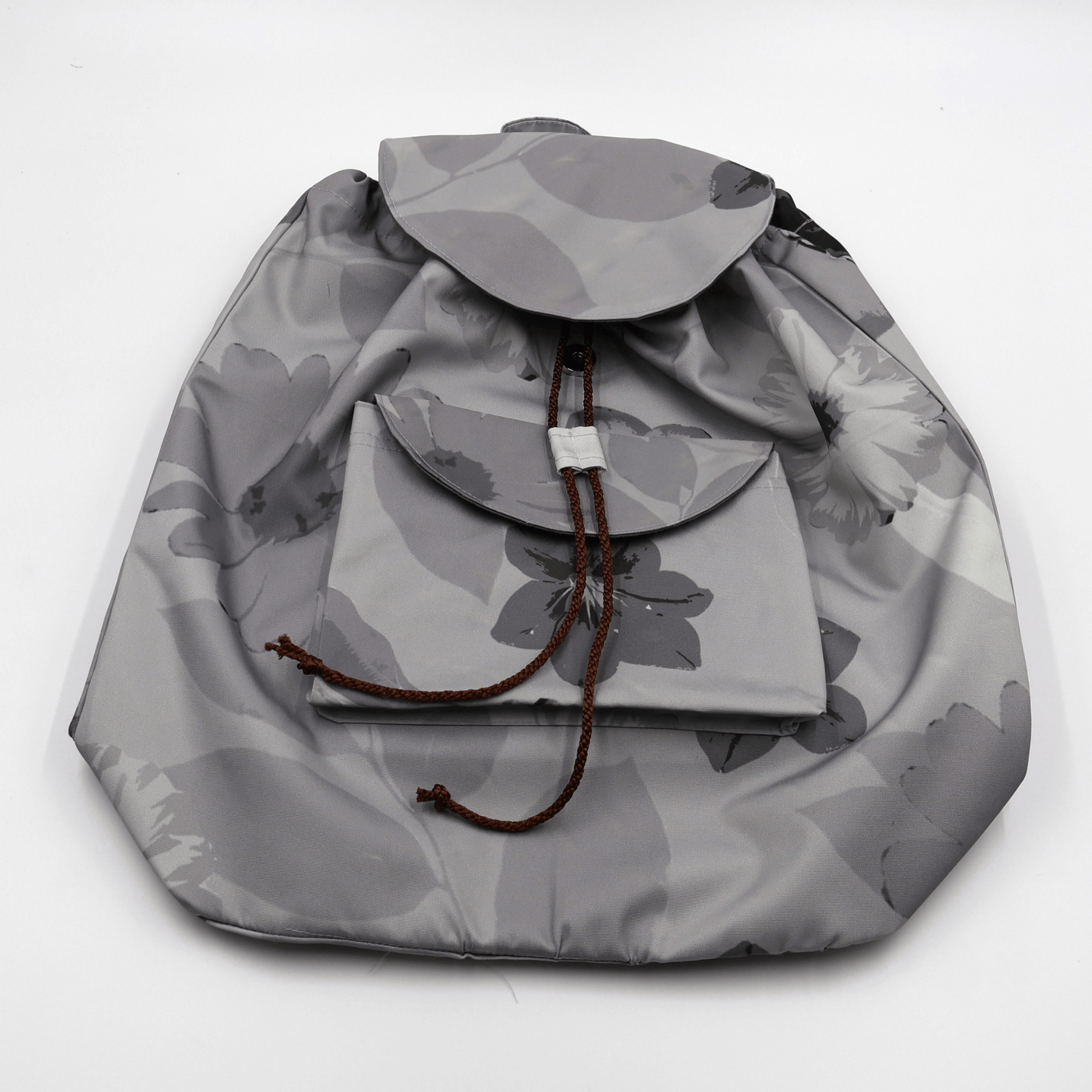 Lightweight backpack with drawstring and daisy floral design in dark and light greys. Flat View.