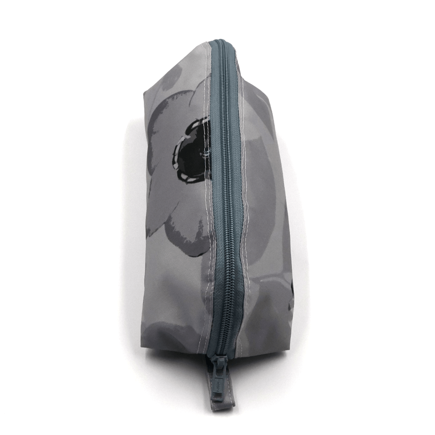 Pencil bag in soft and dark grey daisy floral design on light grey background. Top view of closed zipper.