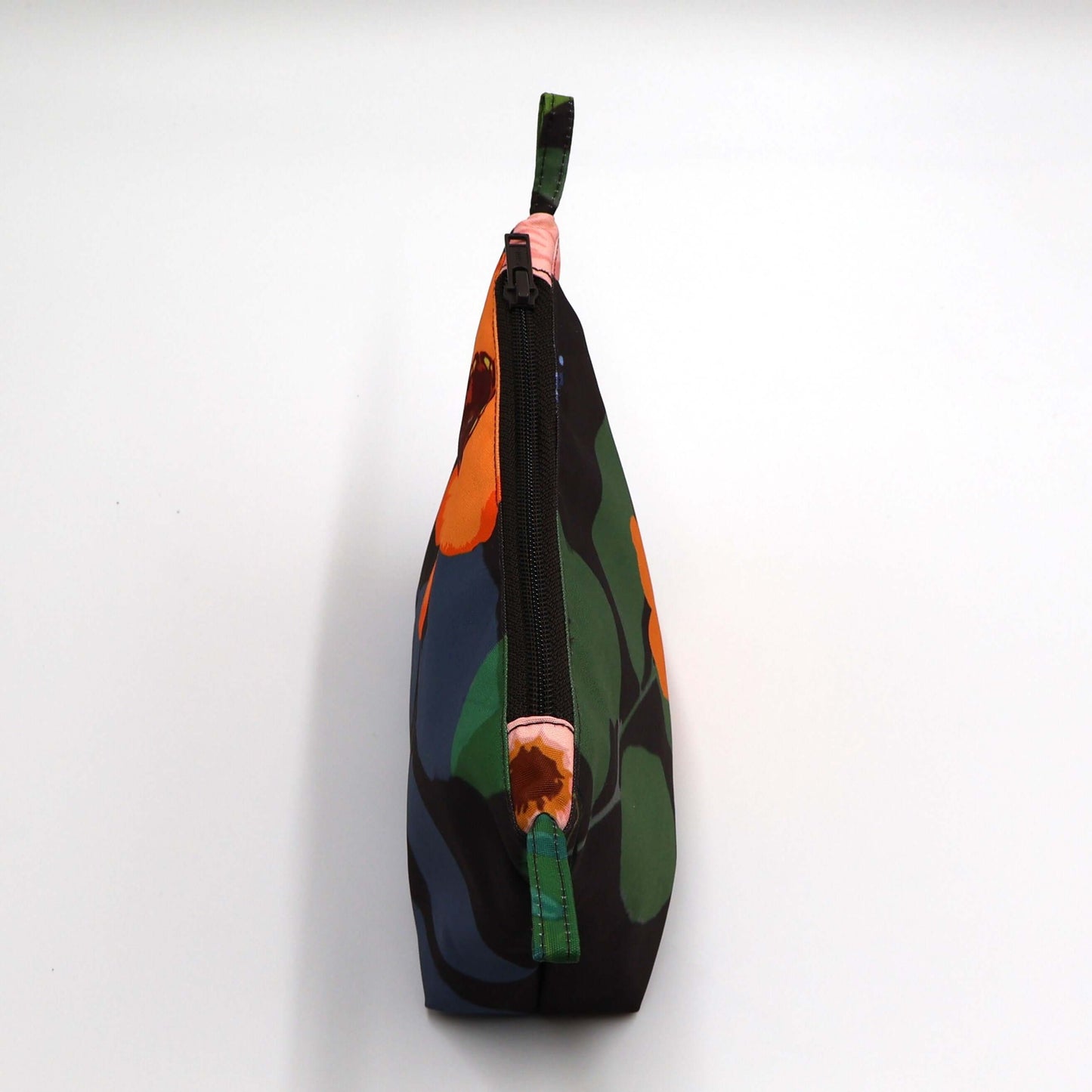 Dark brown/black makeup bag with colorful floral design perfect for organizing beauty products. Zipped closure.