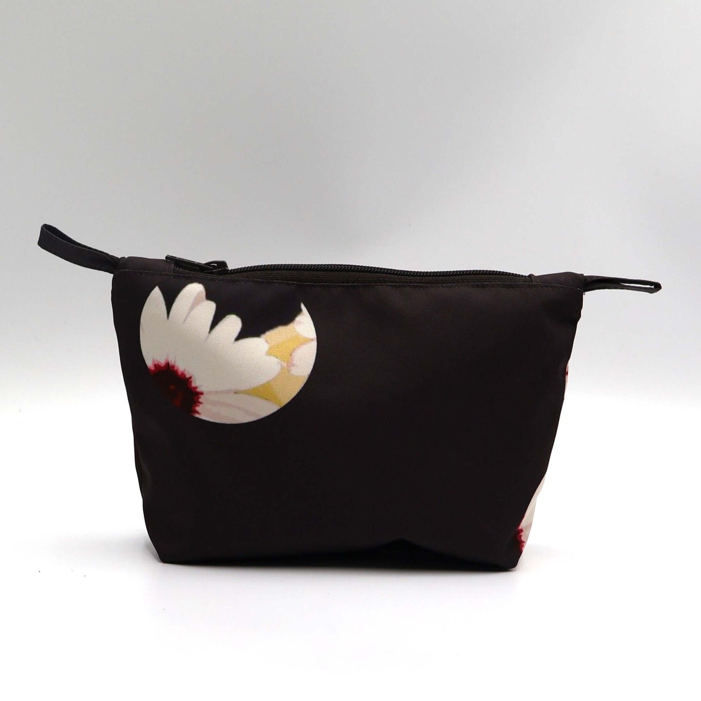 Dark brown/black makeup bag with white daisy floral design, perfect for organizing beauty products.