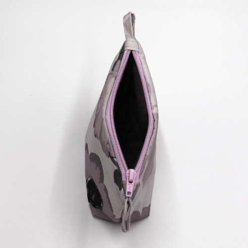 Makeup bag in mauve, dark grey and dusky grey floral design. Open zipper. Top view.