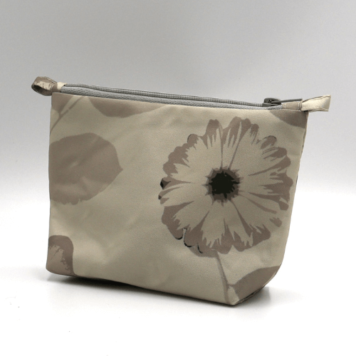 Ellie Bosch beige and ivory floral makeup bag, zipped closure, perfect for organizing beauty products. Side view.