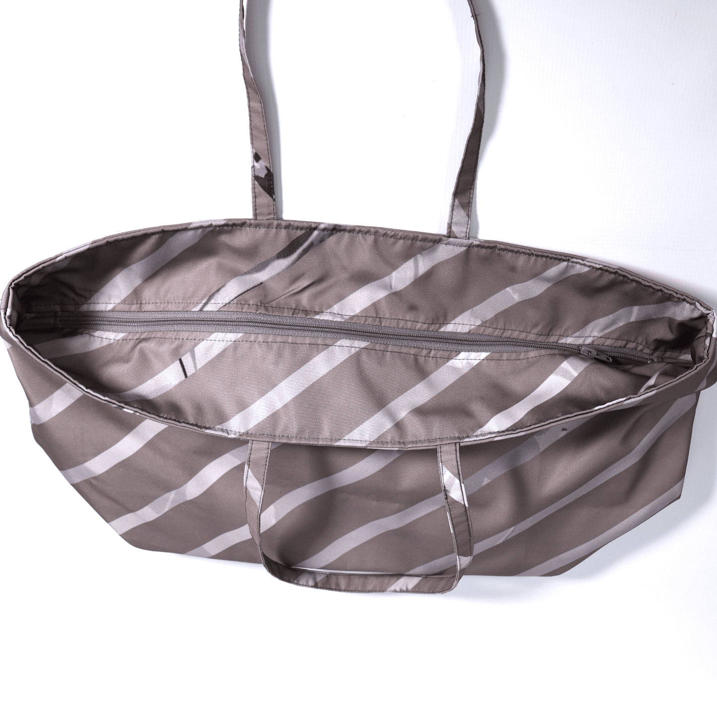 A dark mauve carryall bag with light grey diagonal stripe design. Top view. Closed zipper.