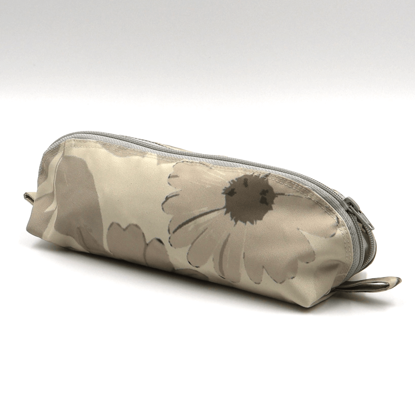 Pencil bag in beige and brown daisy floral design on soft ivory background. Side view.
