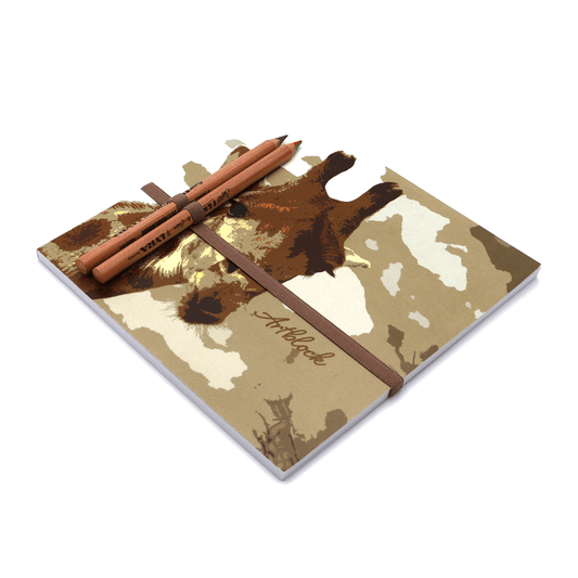 Square art pad with head of young giraffe on cover with multicolour pencils in pencil holder.