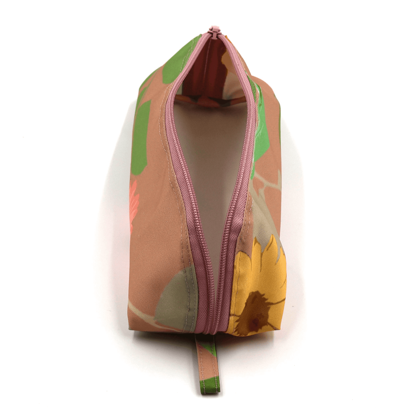 Pencil bag in bright colourful daisy floral design on peach background. Top view open.