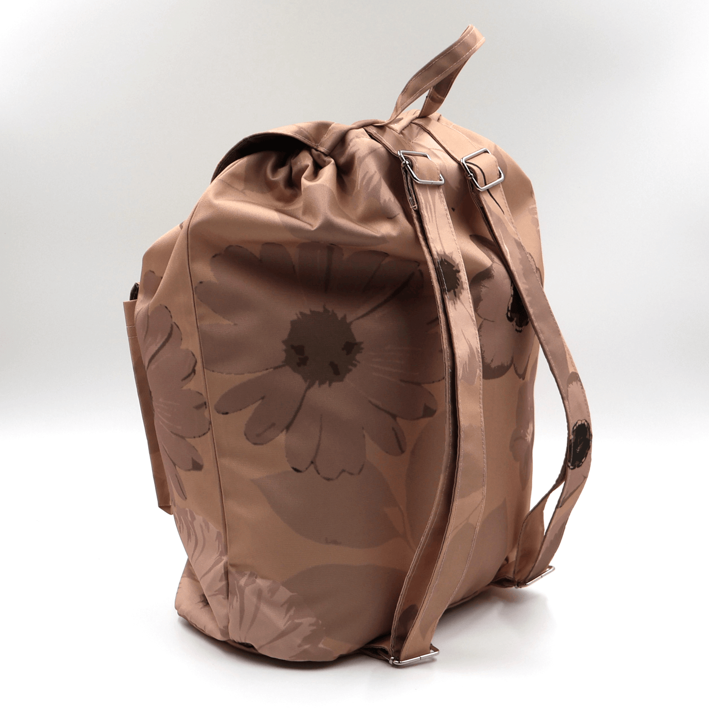 Lightweight backpack with drawstring and daisy floral design in dark and light rusty orange and peach. Side angle.