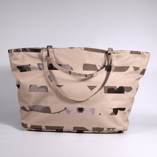 A dusky light peach carryall bag with a stripe design.