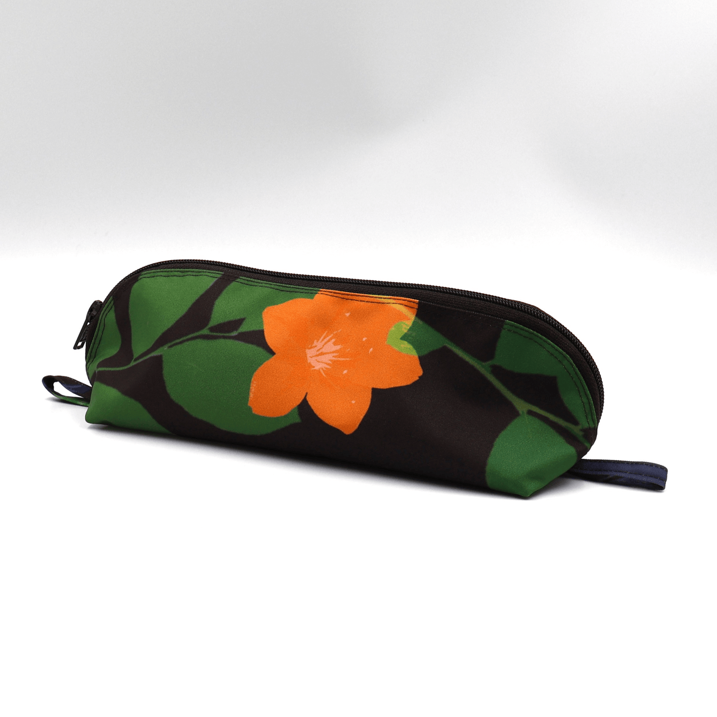 Pencil bag in bright colourful daisy floral design on dark brown/black background. Side view.