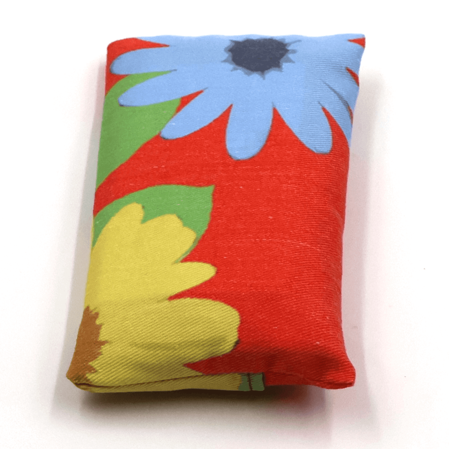 Fold up shopping bag in bright daisy floral design on red background.