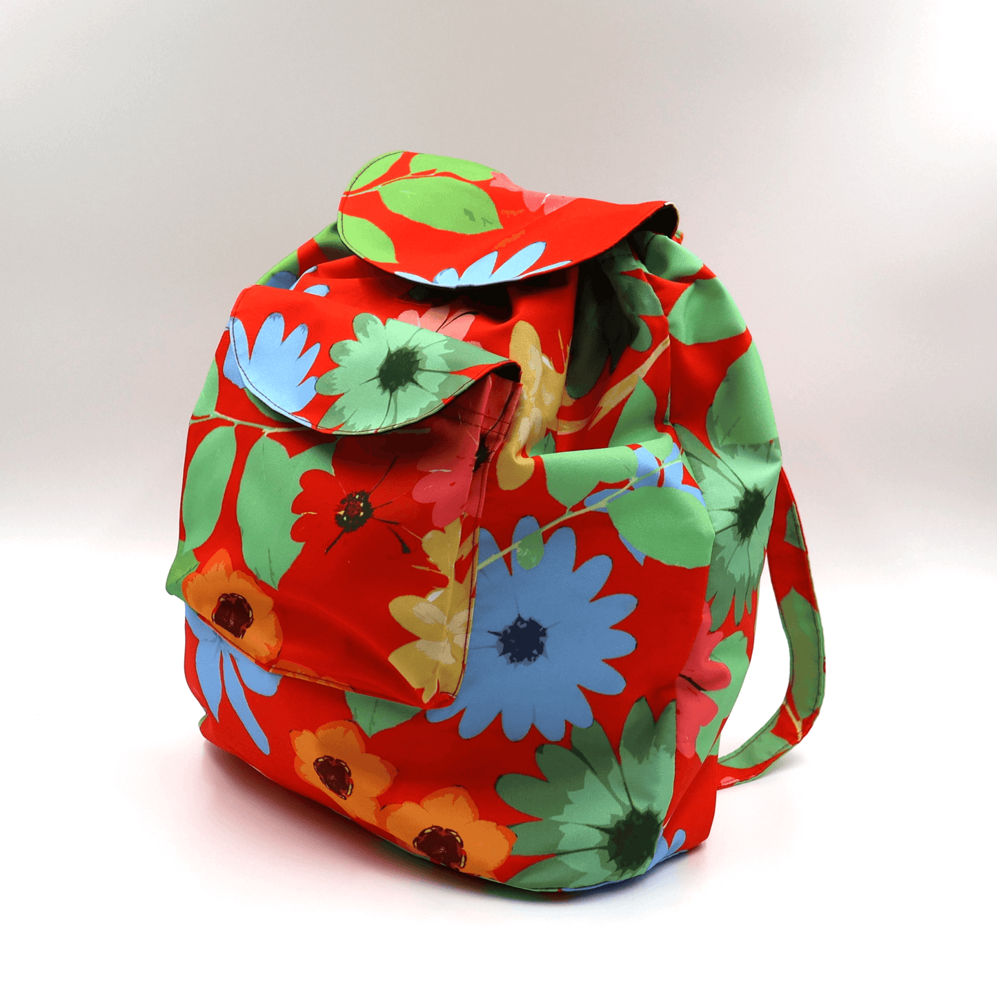 A lightweight, durable backpack with bright, colourful Daisy design on a red background. High-quality materials. Side view