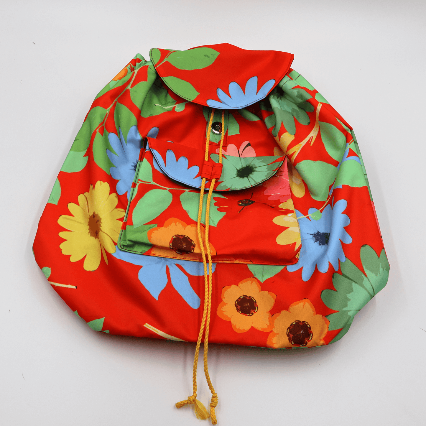 A lightweight, durable backpack with bright, colourful Daisy design on a red background. High-quality materials. Flat view.