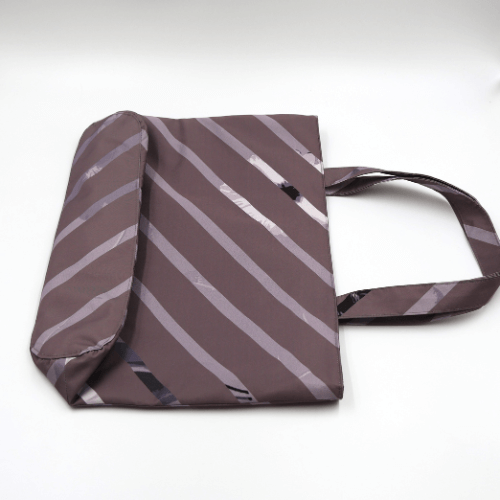 Shoulder bag with stripe design in dark and light mauve. Perfect for carrying books and documents. Flat view.