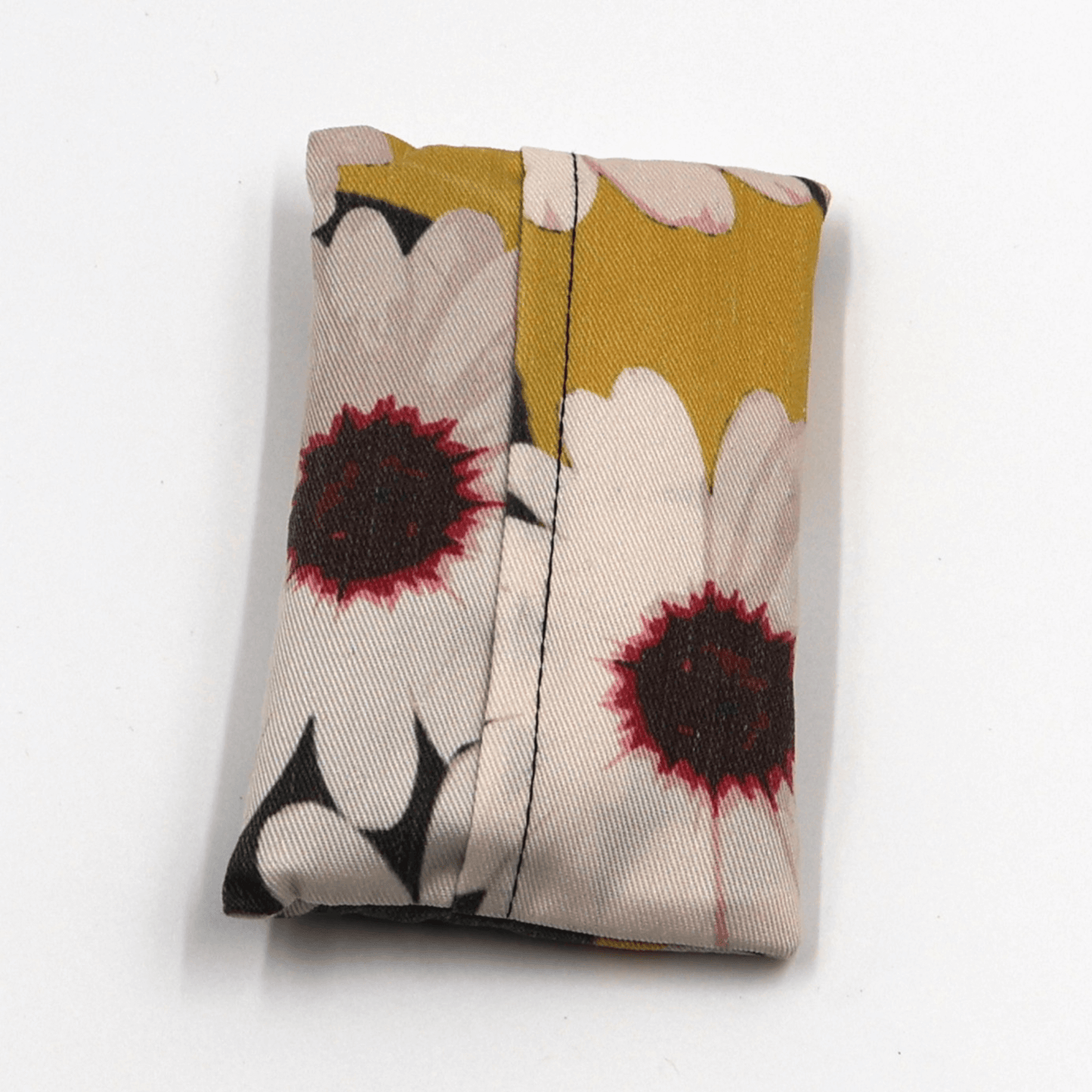 Fold up shopping bag with a white daisy floral design on a black background. Fold view.