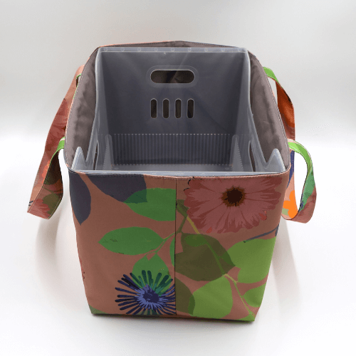 Large teacher/book bag with bright floral daisy design on a dark peach background. With plastic inner.