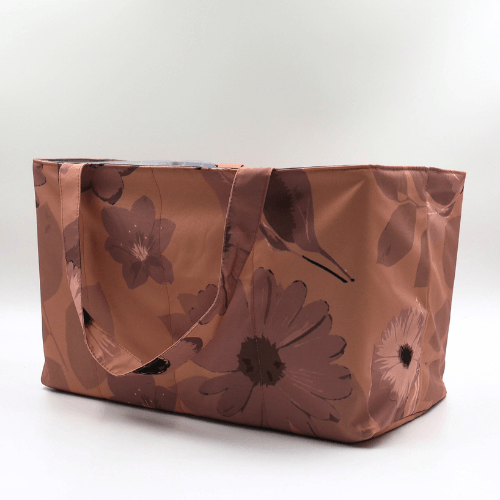 Large teacher/book bag with daisy floral design in rusty orange, brown and dark peach. Side view