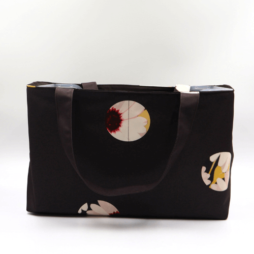 Large teacher/book bag with white abstract daisy design on a black background. Carry books and crafts.