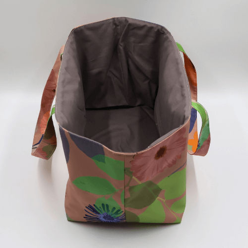 Large teacher/book bag with bright floral daisy design on a dark peach background. Without plastic inner.