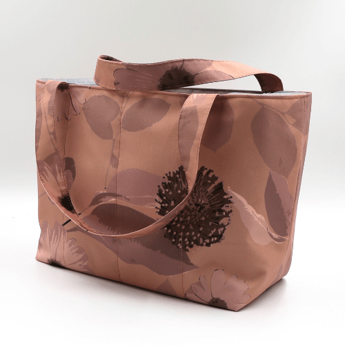 Medium teacher/book bag with daisy floral design in rusty orange, brown and dark peach. Side view.