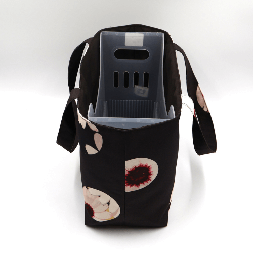 Medium teacher/book bag with white abstract daisy design on a black background. With plastic inner.